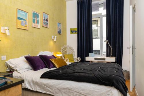 a bedroom with a bed with a black blanket on it at Chambre De Charme Aux Chartrons in Bordeaux