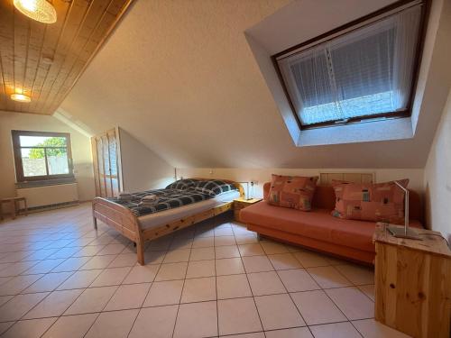 a bedroom with a bed and a couch in it at Gästehaus Ritz in Wintrich