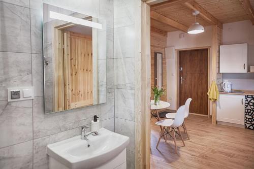 a bathroom with a sink and a mirror and a table at Leśne Siedlisko in Józefów