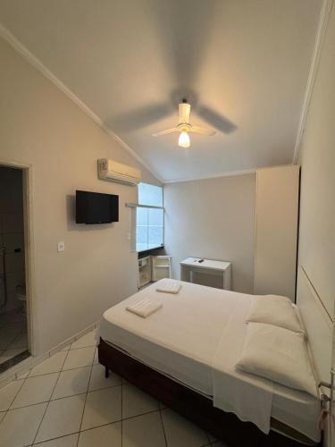 a bedroom with a bed and a ceiling fan at Hotel Avenida ao lado do shopping in Guaratinguetá