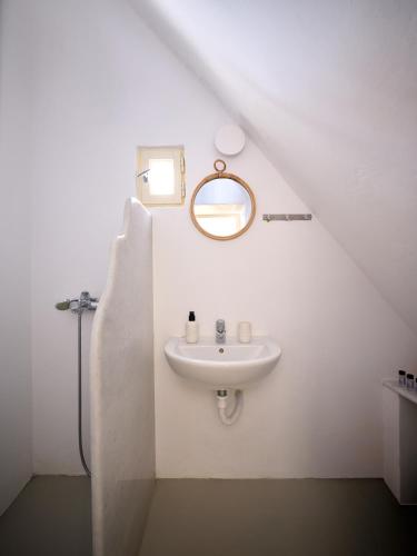 a white bathroom with a sink and a mirror at Flair Naousa in Naousa