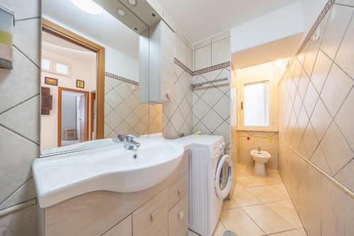 a bathroom with a sink and a washing machine at Piazza Pia Suites in Anzio