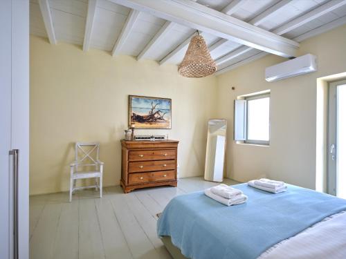 a bedroom with a blue bed and a wooden dresser at Flair Naousa in Naousa