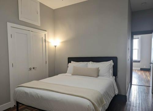 a bedroom with a large bed with white sheets at Modern Downtown Loft Walk to Convention Center in Richmond