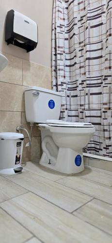 a toilet in a bathroom with a shower curtain at Rivera Solea in Llano de Los Patos