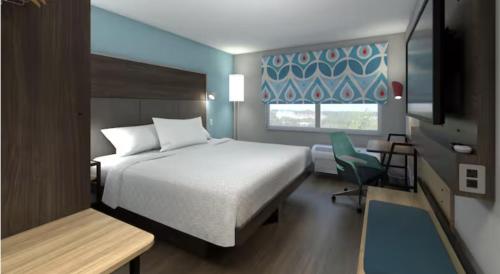 a bedroom with a bed and a chair and a window at Tru By Hilton Ciudad Valles in Ciudad Valles