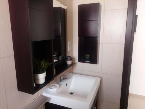 a bathroom with a white sink and a mirror at corali in Tersephanou