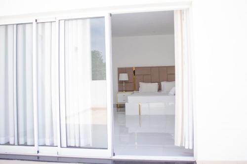 an open sliding glass door in a bedroom with a bed at Hotel Kilimanjaro in Luanda