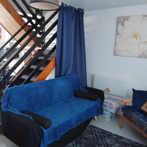 a living room with a blue couch and a staircase at Dawlish Warren Welcome Family Holiday Park Villa Clover Welcome2Warren South Devon in Dawlish Warren