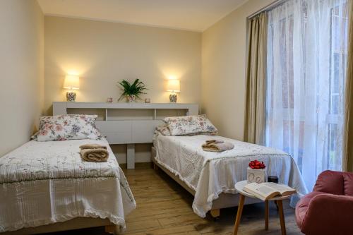 a bedroom with two beds and a window at Apartamenty 40 in Ciechocinek