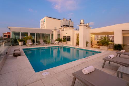 a swimming pool in front of a house at Four Points by Sheraton Barranquilla in Barranquilla