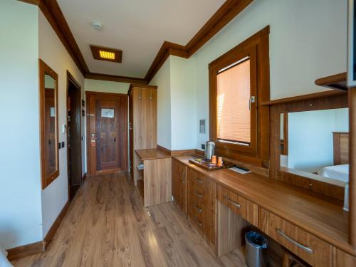 a bathroom with wooden cabinets and a large window at Hotel Azmakhan in Akyaka