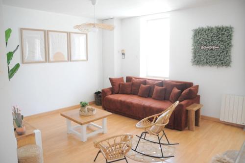 a living room with a brown couch and chairs at À 8min du parc LE PAL Le cocon de Kenna in Dompierre-sur-Besbre