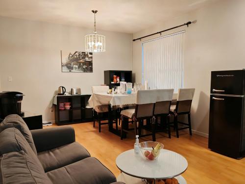 a living room with a couch and a table with chairs at Bed Plus One in House in Richmond