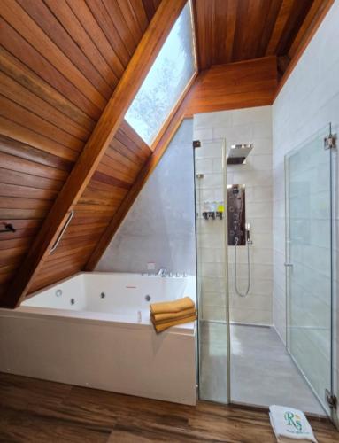 a bathroom with a large tub and a glass shower at Riosol Laguna Azul in Sauce