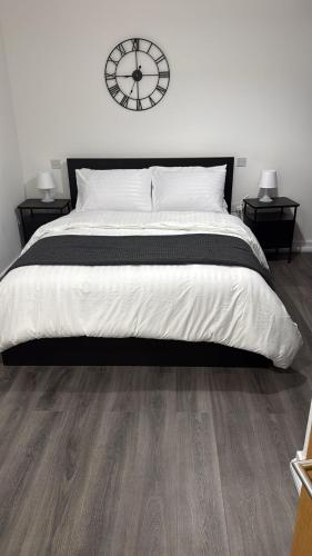 a bedroom with a large bed with a clock on the wall at Malijeed Services limited in London