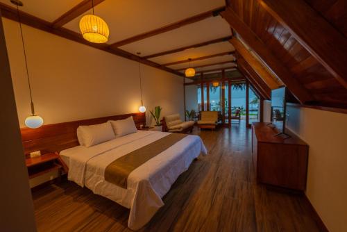 a bedroom with a bed and a living room at Riosol Laguna Azul in Sauce