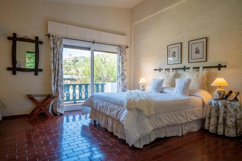 a bedroom with a bed and a large window at Posada los Cedros in La Cumbre