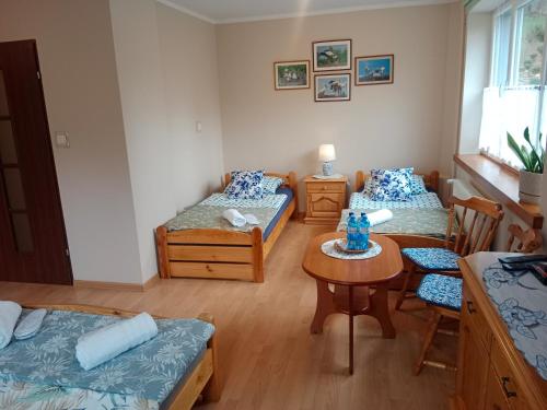 a room with two beds and a table and chairs at ZŁOTY BUK in Jagniątków