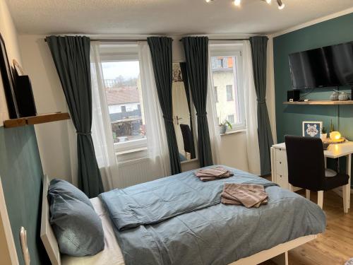 a bedroom with a bed and a desk and a window at OESLAUER STUBE Gemütliches Apartment mit Kamin, Klimaanlage, Balkon, 3 Schlafzimmern, 2 Bädern, Modern, Familienfreundlich, Zentral, Vollausgestattet in Rödental