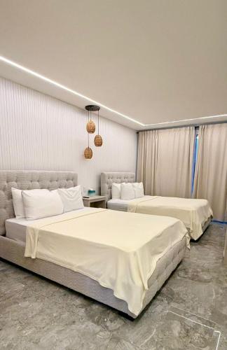 two beds in a hotel room with two beds at Caye Caulker Condos in Caye Caulker