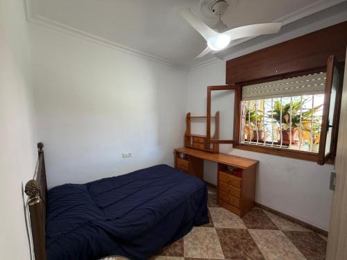 a bedroom with a bed and a desk and a window at Chalet con Piscina Aguadulce in Aguadulce