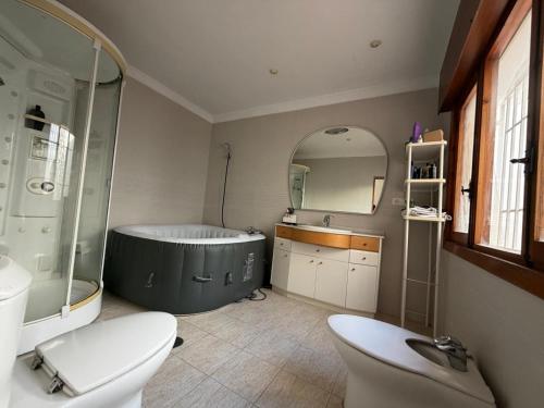 a bathroom with a tub and a toilet and a sink at Chalet con Piscina Aguadulce in Aguadulce