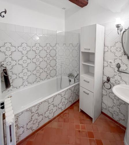 a bathroom with a white tub and a sink at À minnanna in Banon