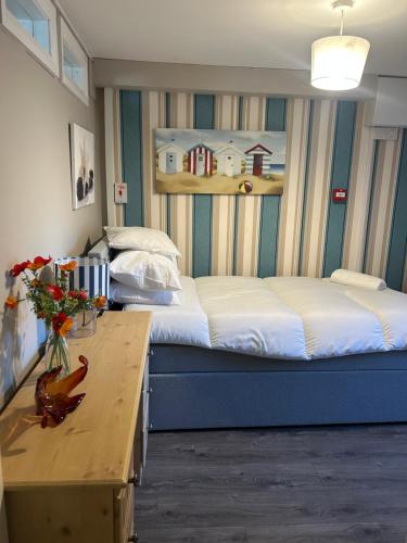 a bedroom with a large bed and a wooden table at 7 The Diamond in Ballycastle