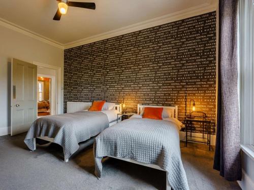 two beds in a bedroom with a brick wall at 5 Bed in Sandown oc-87008 in Sandown