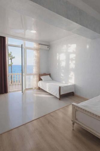 a bedroom with two beds and a large window at У Царицы in Kobuleti