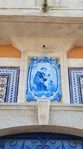 a blue and white picture on the side of a building at Casa de St António in Murtosa