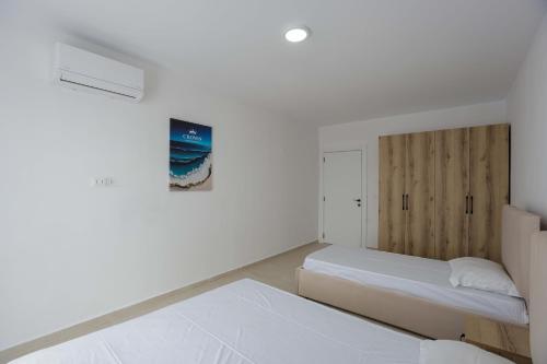 a bedroom with a bed and a wooden headboard at Crown Apartments in Golem
