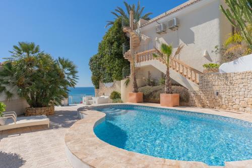 a villa with a swimming pool next to the ocean at Maryvilla Inspiración y Vacaciones - Villa Mascarat in Calpe