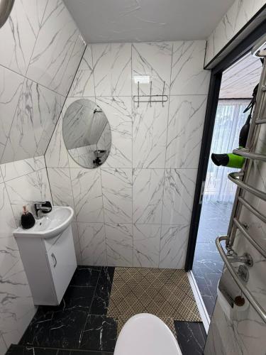 a white bathroom with a toilet and a sink at A-frame У Евелінки in Vorokhta