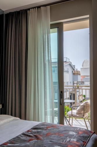 a bedroom with a bed and a large window at The Marni Hotel & Spa - Adults Only 12 Plus in Antalya