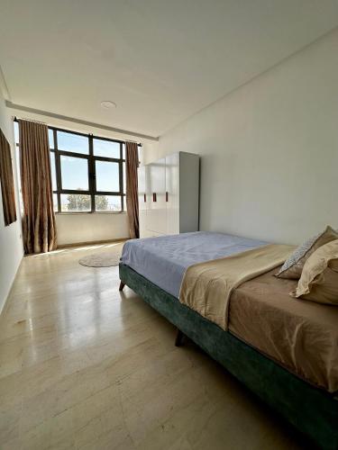 a bedroom with a large bed and a large window at Appartement Laetitia, hyper centre hammamet in Hammamet