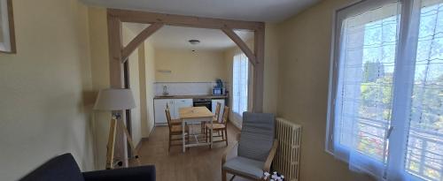 a living room with a table and chairs and a kitchen at Résidence Mauriac in Mauriac