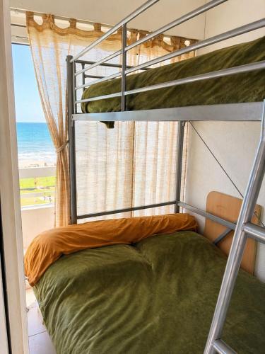 a bunk bed in a room with a view of the ocean at Studio cabine pied dans l eau climatisé, parking et wifi haut débit in Canet-en-Roussillon