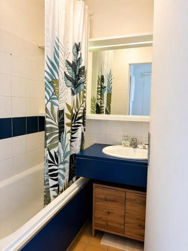 a bathroom with a sink and a shower curtain at Studio cabine pied dans l eau climatisé, parking et wifi haut débit in Canet-en-Roussillon