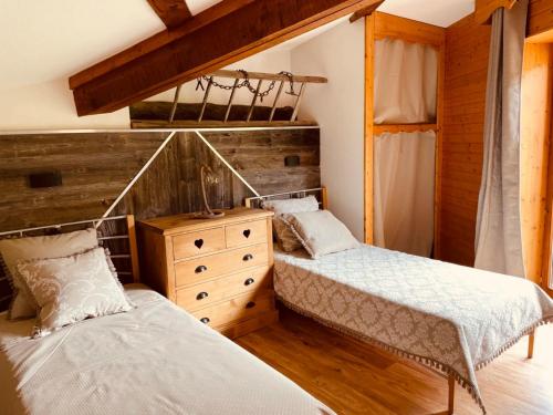 a bedroom with two beds and a dresser at Duplex « les 7 Marmottes », 306 in Chamrousse
