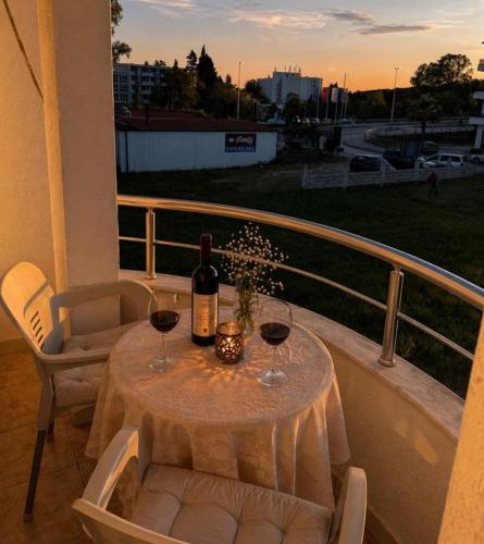 a table with a bottle of wine and two glasses at Long Beach Truma in Ulcinj