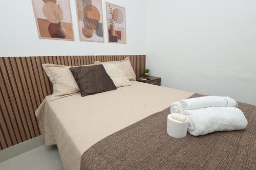 a bedroom with a bed with a pillow and a towel at Pousada House Garden in Goiânia