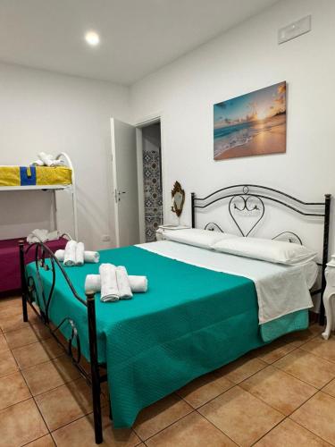 a bedroom with a bed with a green and white blanket at DomusVenere in Santa Croce Camerina