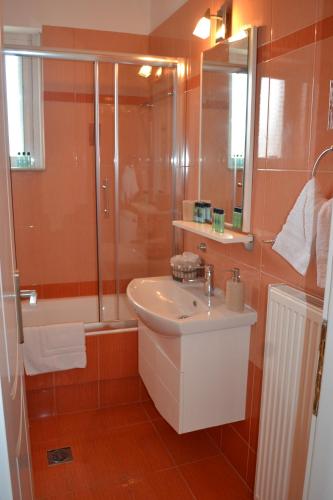 a bathroom with a sink and a shower at Skala Central Comfort Apartment in Skála