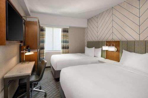 a hotel room with two beds and a desk at Hampton Inn Long Island City NY in Long Island City