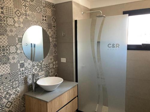 a bathroom with a sink and a mirror at C&R Departamentos y Hoteles in Mar del Plata