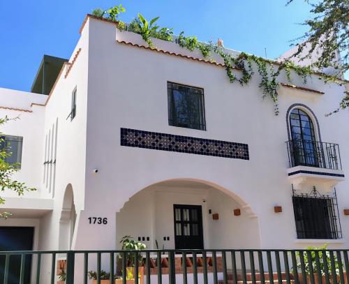 a white building with a black gate at Hospedarte Central Hotel in Guadalajara