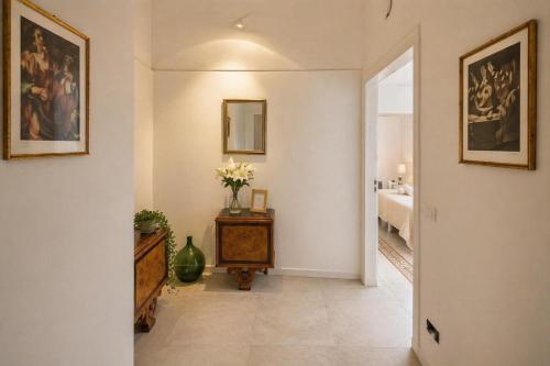 a hallway with a table with flowers and a bedroom at Immacolata Rooms in Noto