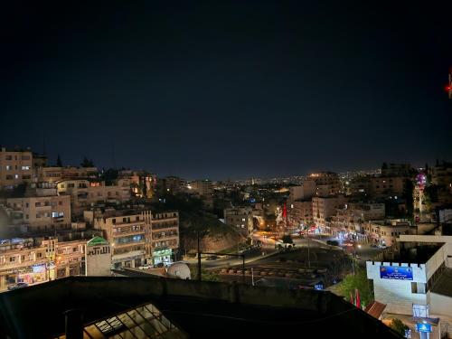 a view of a city at night at Friends Hotel Jordan in Amman